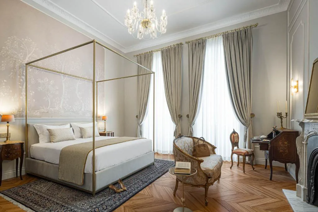 Suite con cama con dosel dorado y papel pintado floral, Palacete Valdemouro