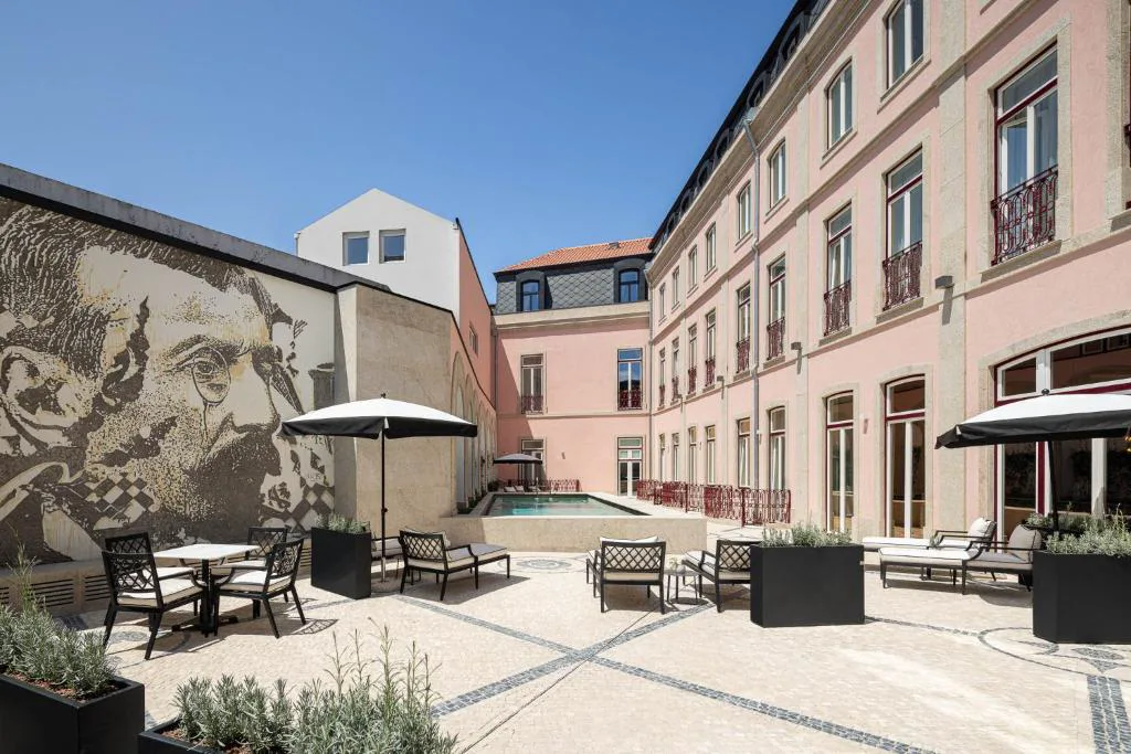 Patio interior con piscina y un mural de arte urbano, Palacete Valdemouro