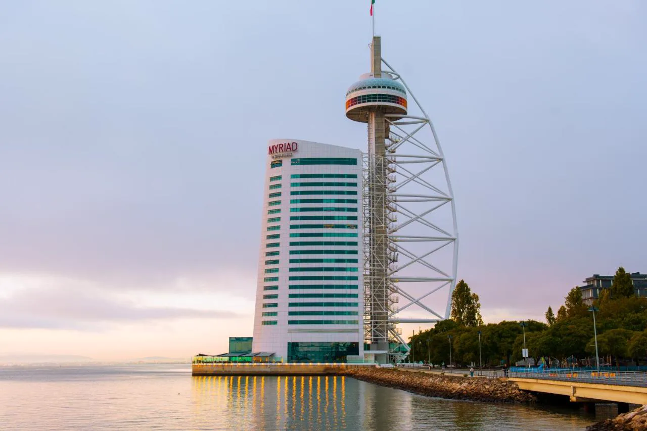 Torre de MYRIAD by SANA Hotels junto a la Torre Vasco da Gama al atardecer, en el Tajo
