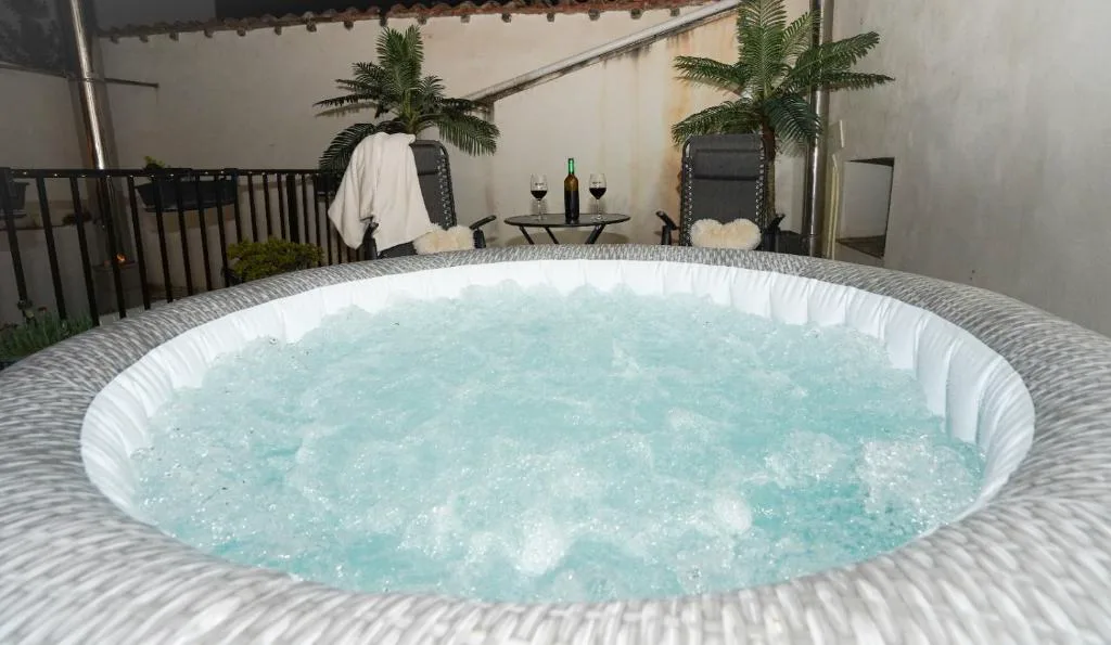 Jacuzzi burbujeante en una terraza con plantas