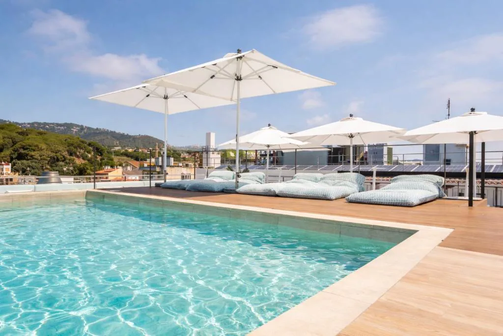 Piscina con sombrillas y vistas a la costa