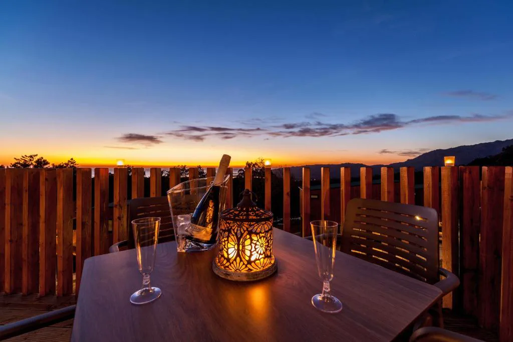 Copas y botella de cava sobre mesa en terraza al atardecer, Nidos de Carnota