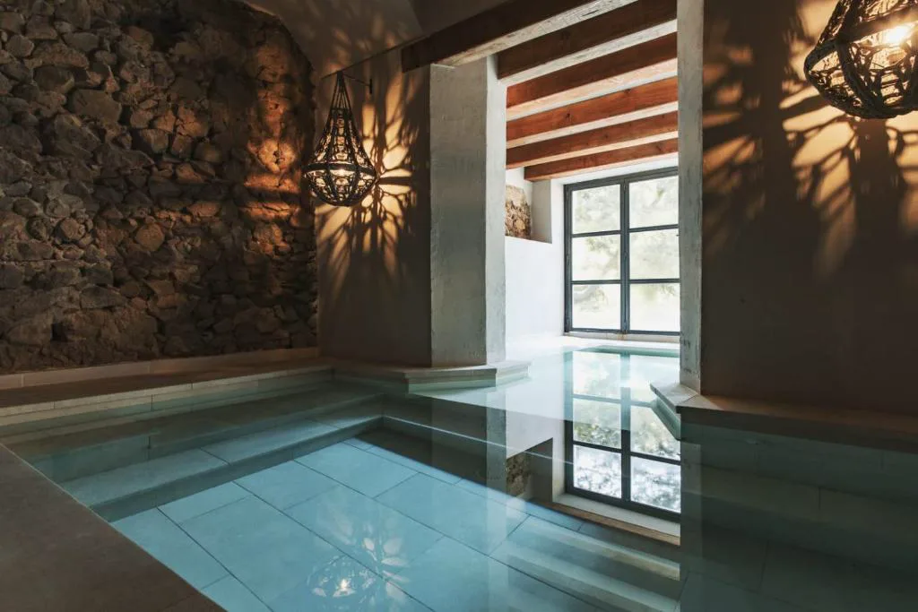 Piscina de spa interior con paredes de piedra