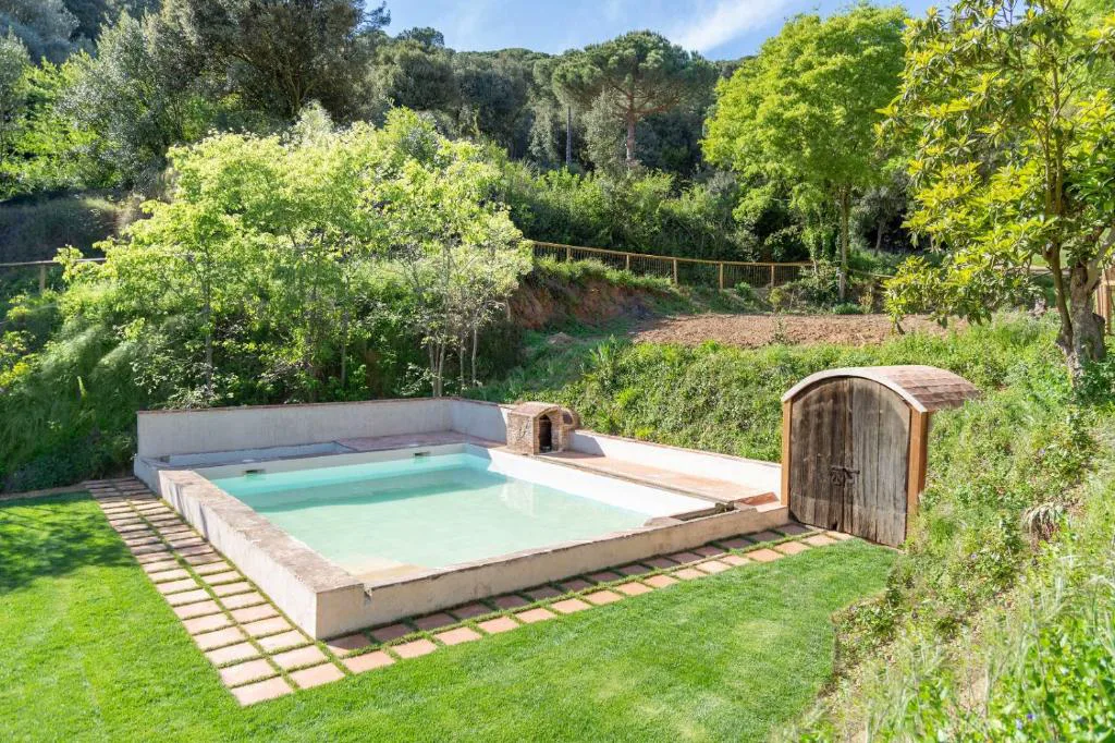 Pequeña piscina exterior con caseta de madera