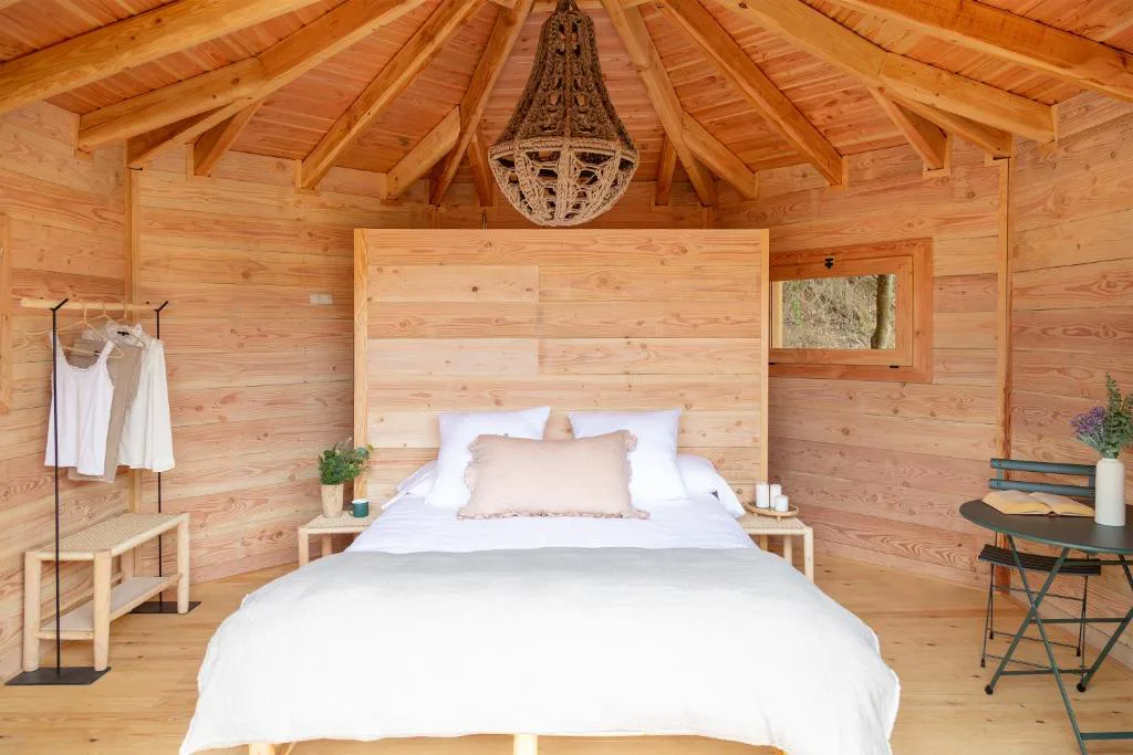 Dormitorio de madera con techo de vigas