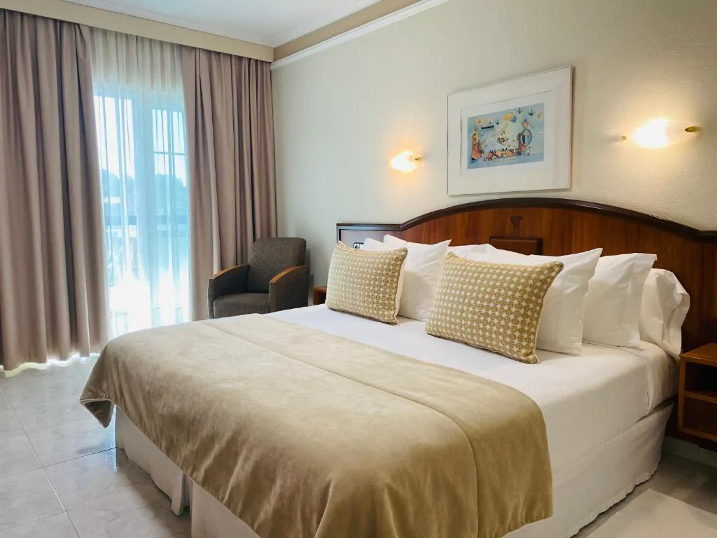 Habitación doble con cabecero de madera y cortinas largas, Nuevo Astur Spa