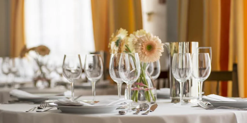Mesa de restaurante vestida con flores y copas de cristal, Nuevo Astur Spa