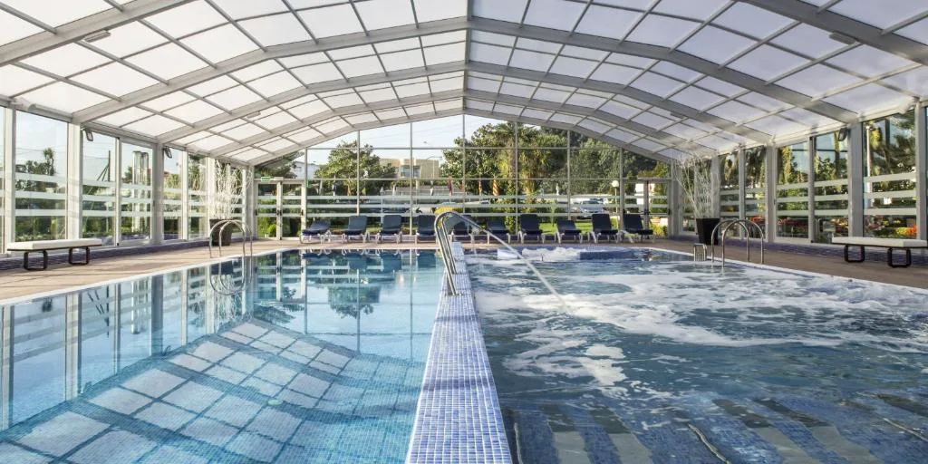 Piscina cubierta acristalada con zona de hidromasaje y chorros de agua, Nuevo Astur Spa, Sanxenxo