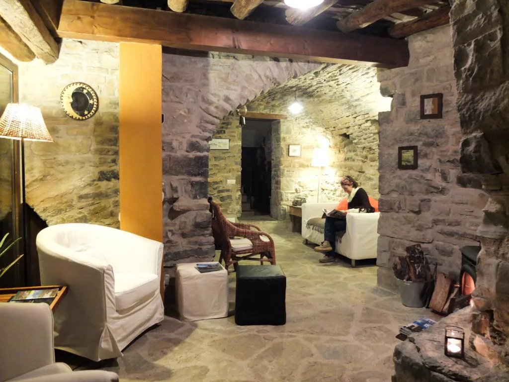 Salón de piedra con arco y sofás claros