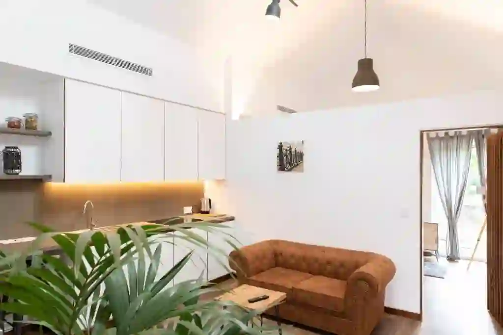 Cocina y salón con sofá chester y techos altos, Casitas O Loureiro