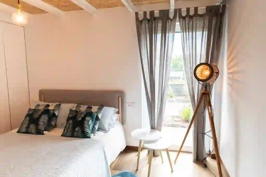 Dormitorio con cabecero tapizado y vistas al jardín, Casitas O Loureiro