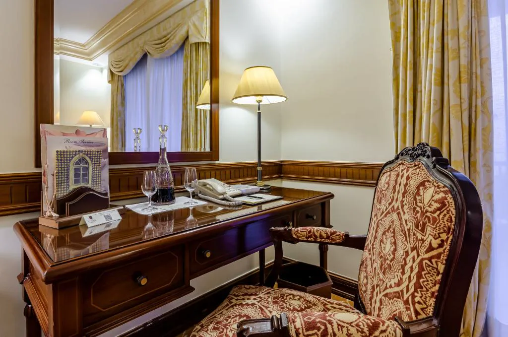 Escritorio clásico con decantador de vino en una suite del Olissippo Lapa Palace