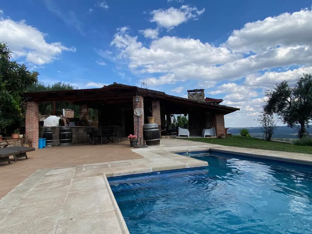 Piscina con porche de ladrillo y vistas a la sierra