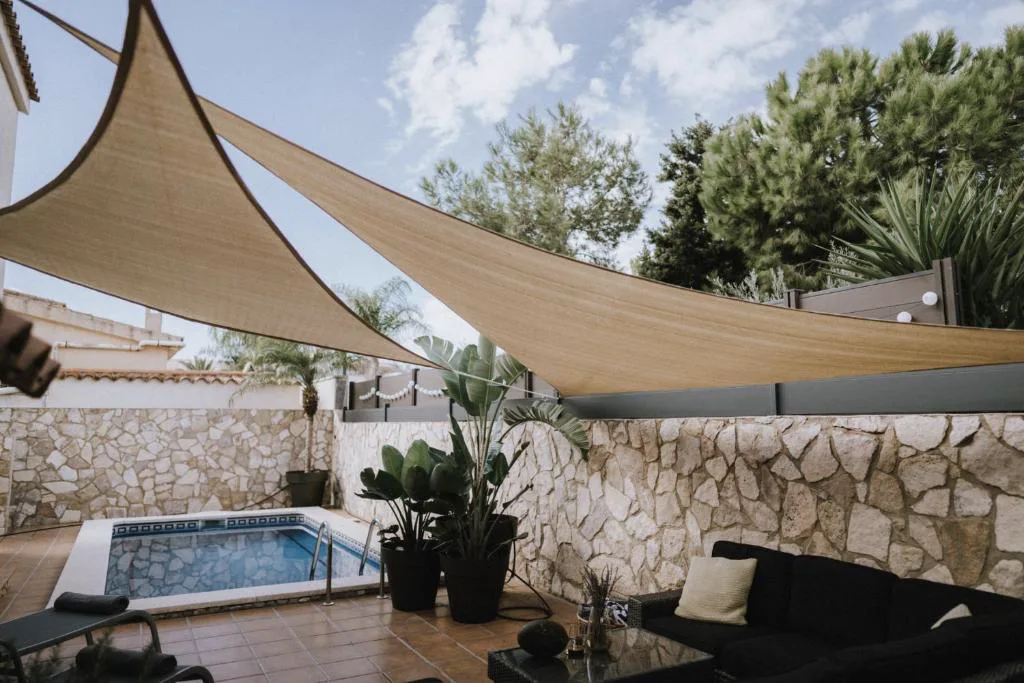 Jacuzzi bajo toldo triangular en el patio