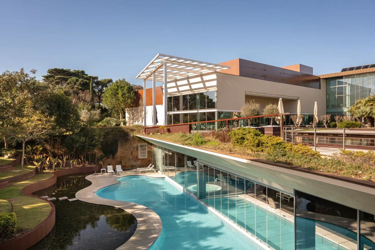 Piscina de formas orgánicas junto al jardín en Onyria Marinha Cascais