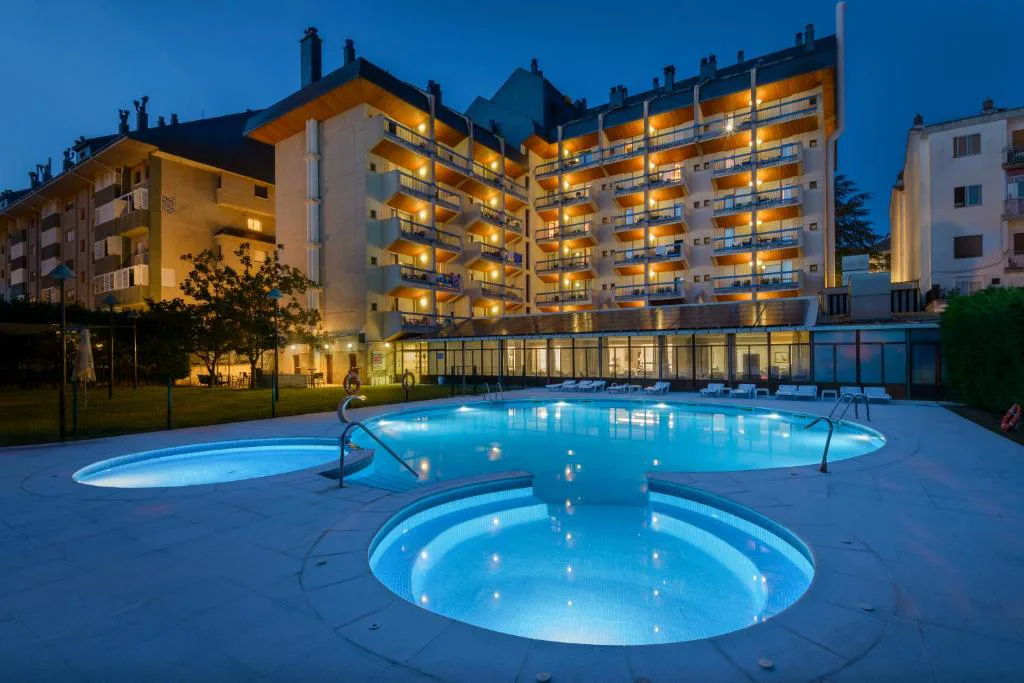 Piscina exterior redonda iluminada delante del hotel