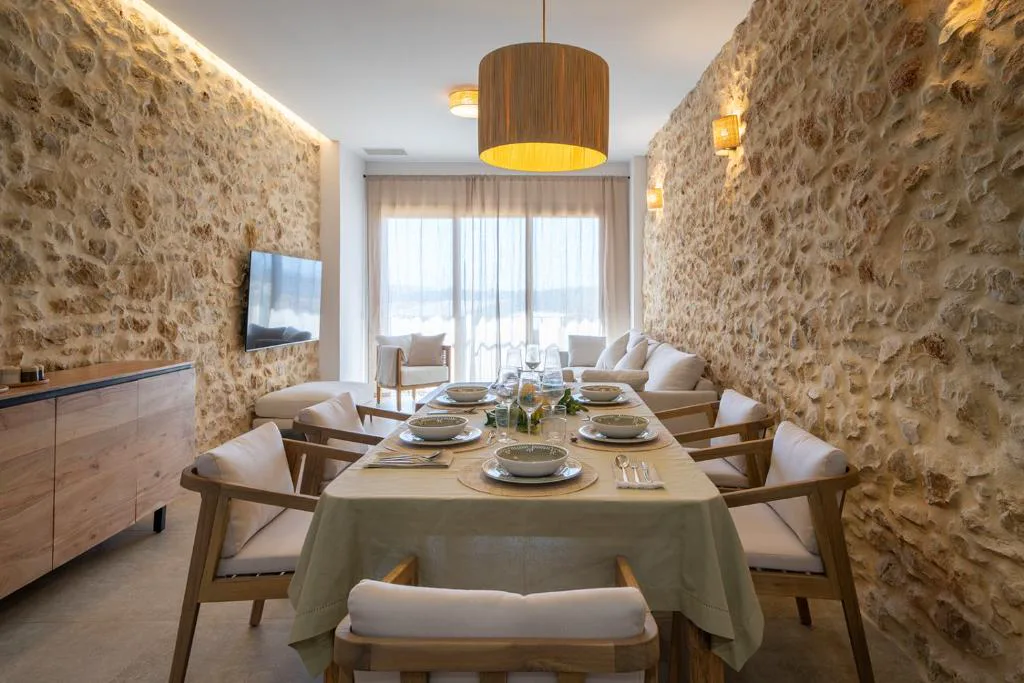 Comedor con pared de piedra y mesa larga