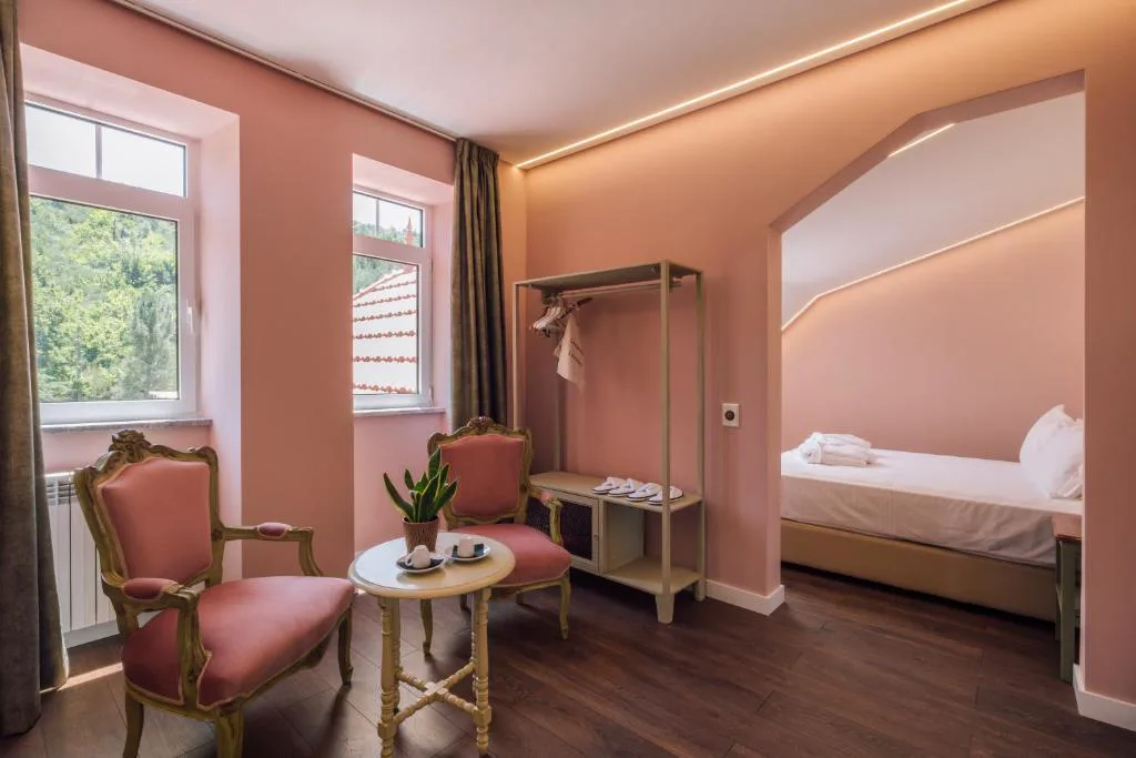 Suite en tonos rosa con sillones de época y vistas a la montaña, Palacete do Guerreiro