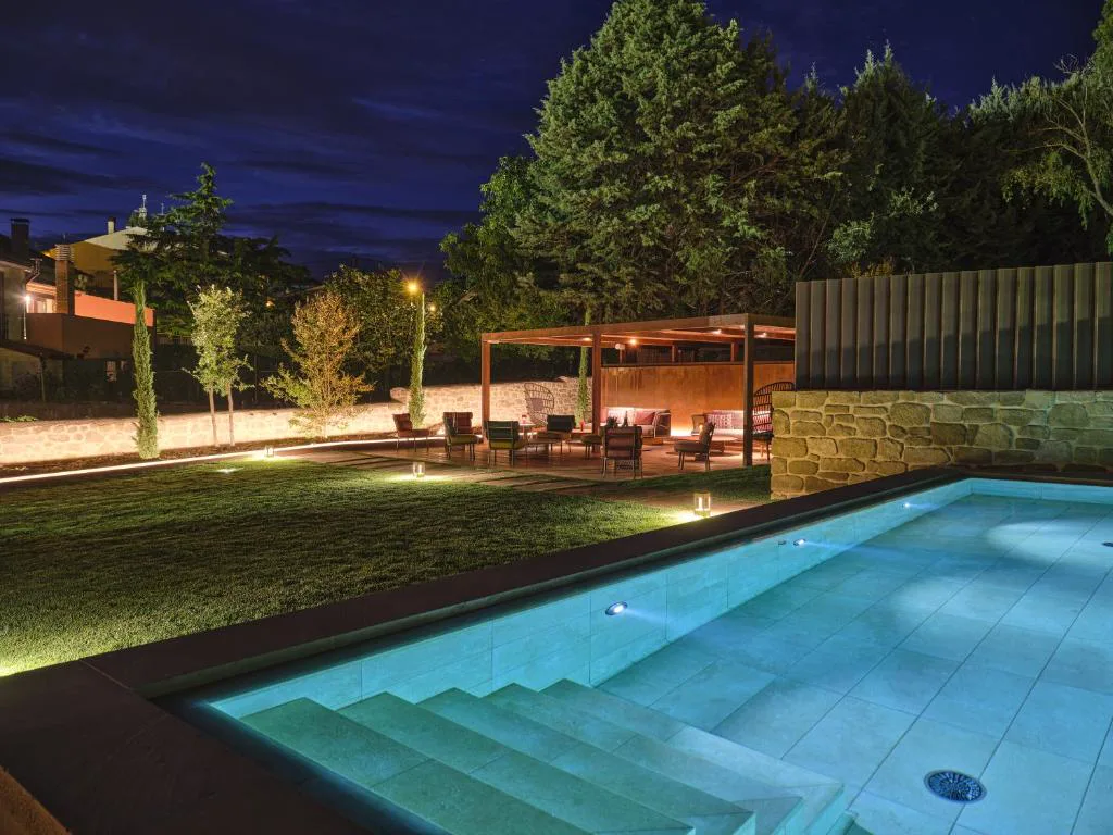Piscina iluminada con escalones de piedra por la noche