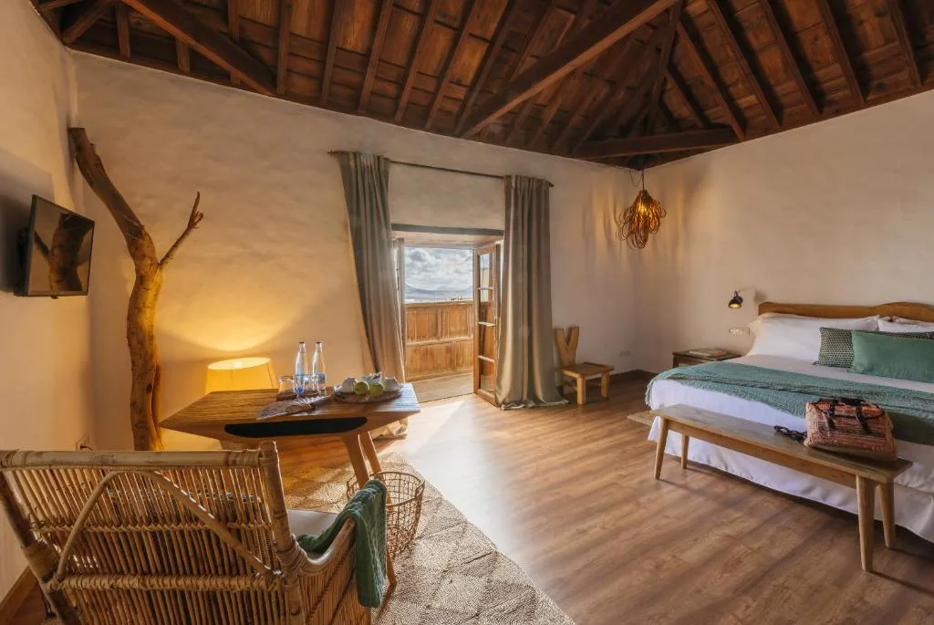 Dormitorio rústico con balcón abierto y vistas al campo, Hotel Boutique Palacio Ico