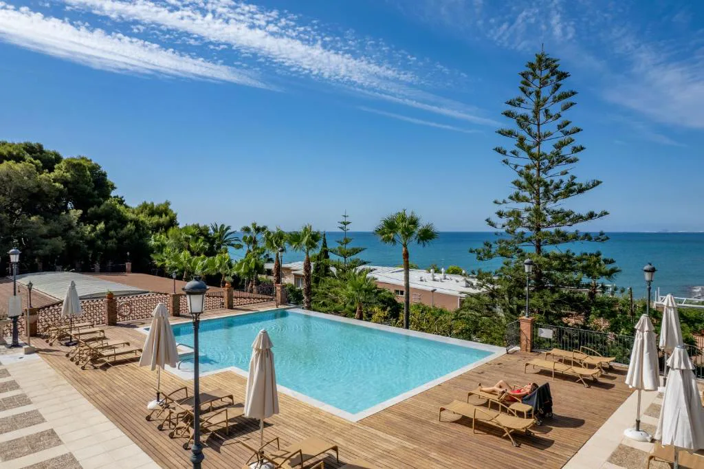 Piscina exterior sobre un mirador con pinos y vistas al mar