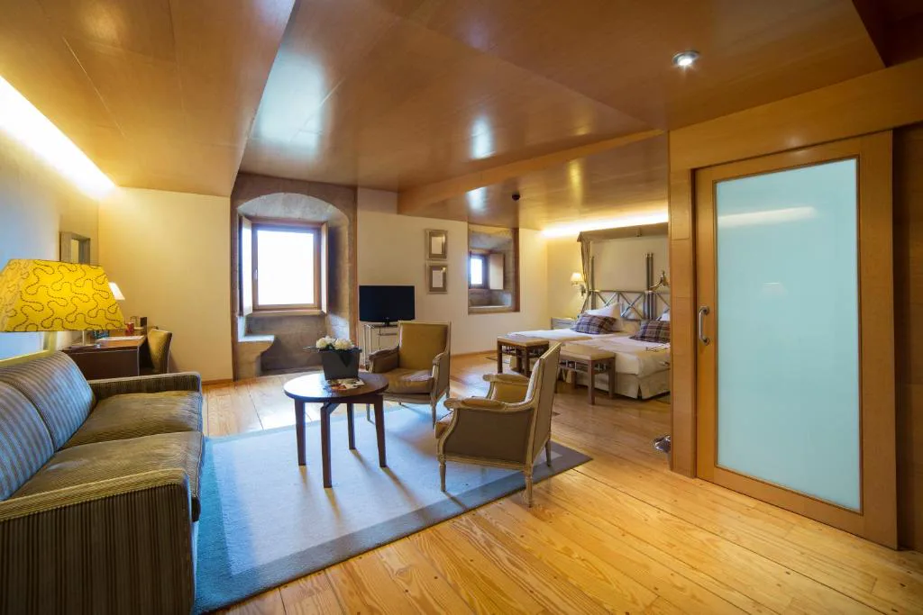 Suite con salón, sillones de época y cama con dosel, Parador de Santo Estevo