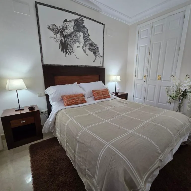 Dormitorio con cabecero de madera y colcha blanca