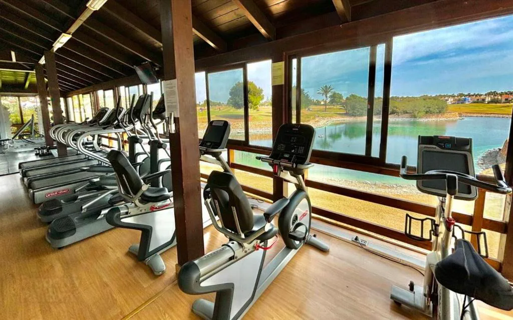 Gimnasio con cintas junto al lago del campo de golf
