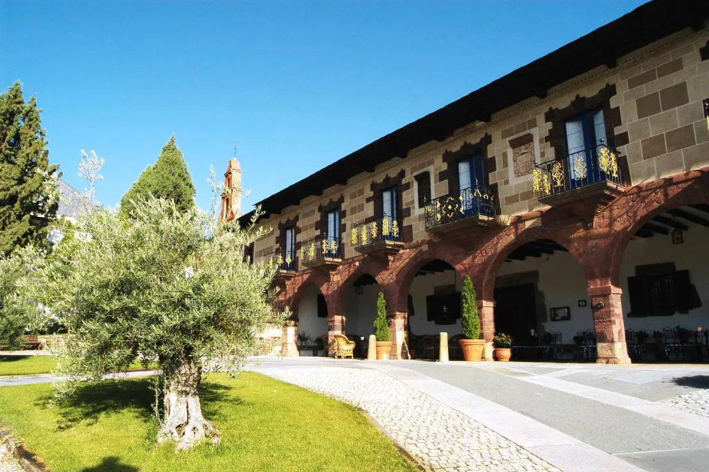 Fachada del pazo del siglo XVII con arcadas de piedra y balcones de forja, Pazo do Castro