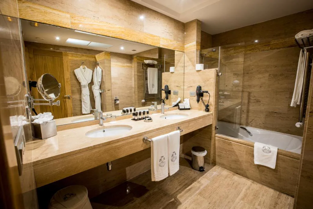 Baño de mármol con bañera, albornoces y ducha de cristal, Pazo Los Escudos