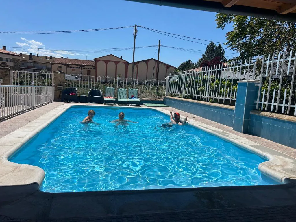 Piscina con valla junto a las casas del pueblo