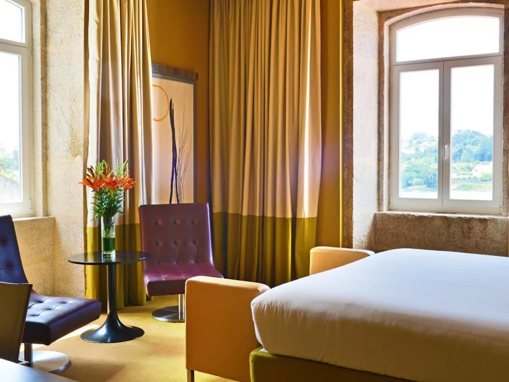 Habitación con arreglo floral y ventanales de piedra original, Pestana Palácio do Freixo