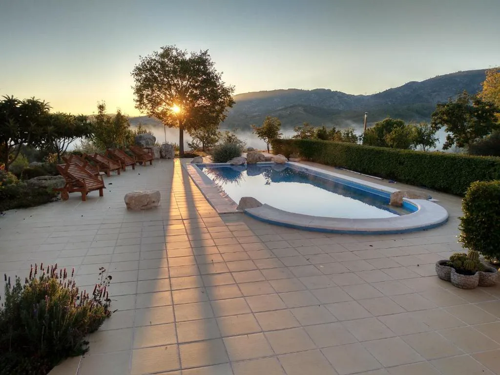 Piscina larga al atardecer junto a una terraza