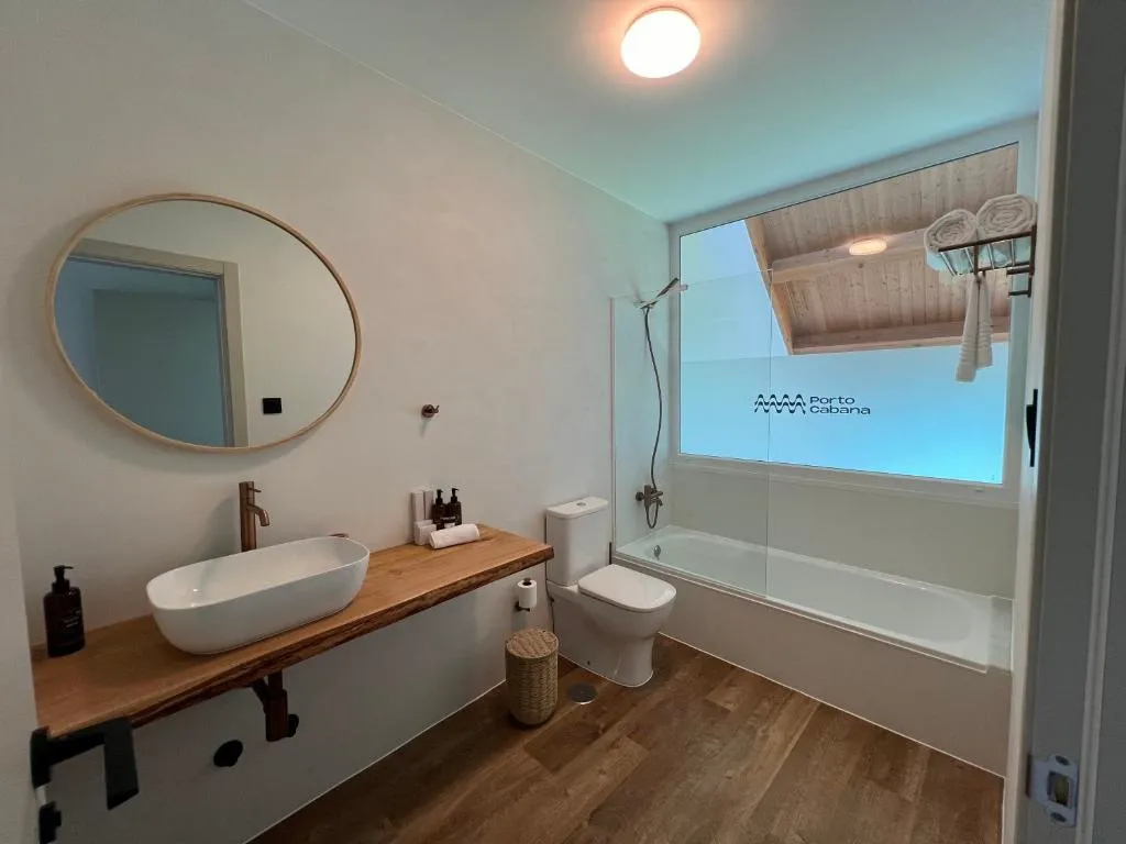 Baño con bañera, mampara de cristal y toallero de madera, Porto Cabana by Miramar Stays