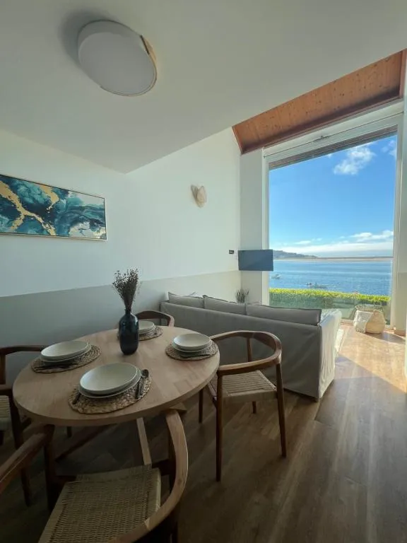 Mesa de comedor con vistas frontales a la ría desde el salón, Porto Cabana by Miramar Stays