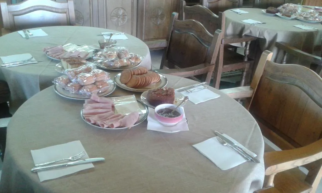 Desayuno servido con bollería sobre un mantel