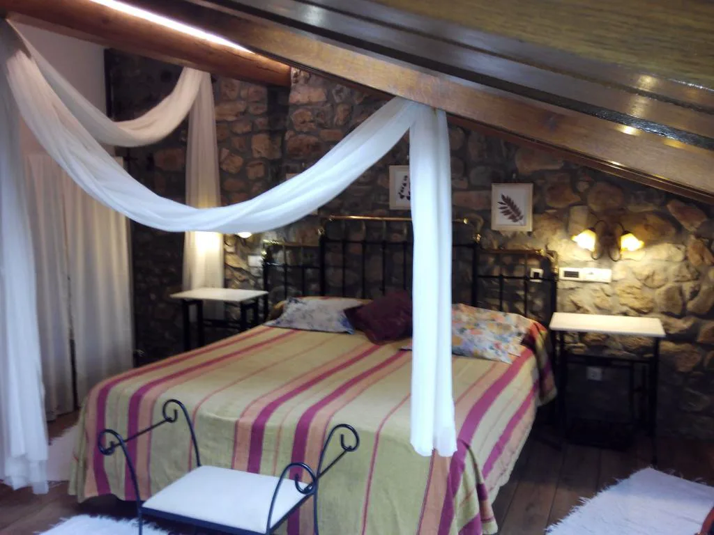 Cama con dosel de gasa blanca y colcha a rayas