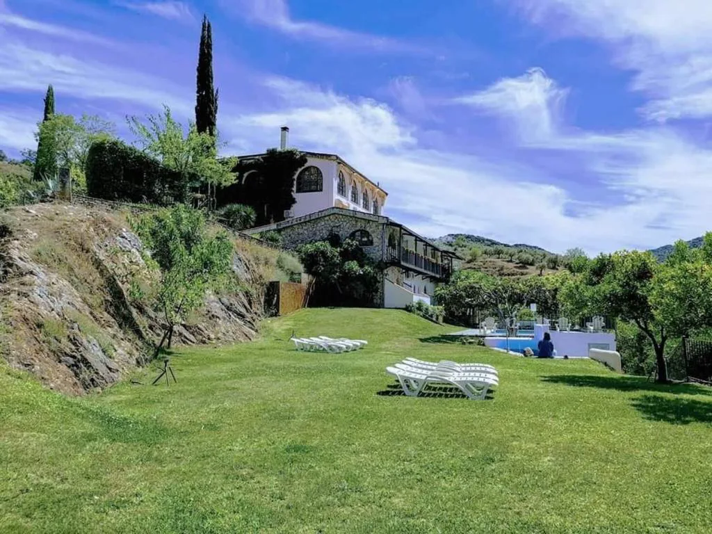 Casa blanca de piedra sobre un jardín de césped con tumbonas en las Arribes