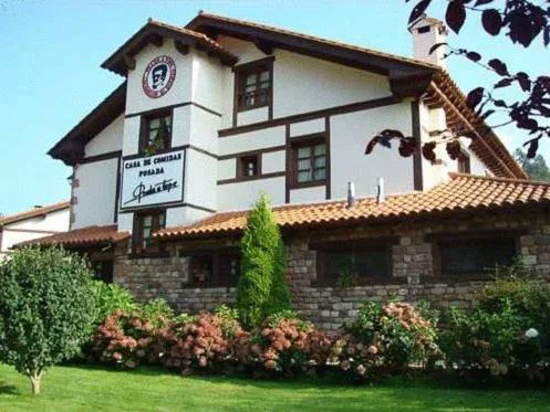 Casona con balcones, jardín y setos de flores