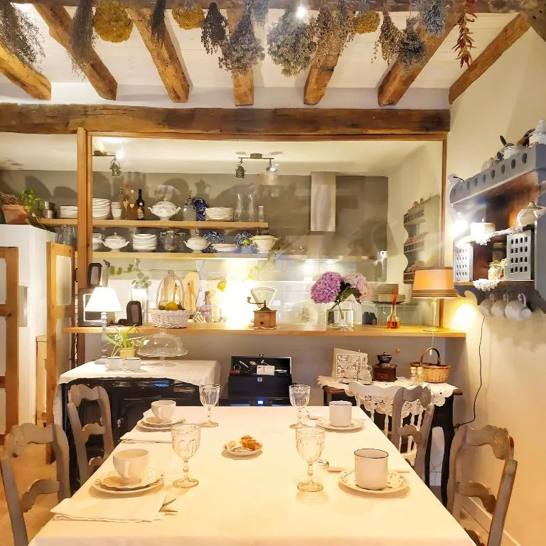 Comedor con vigas y cocina rústica al fondo