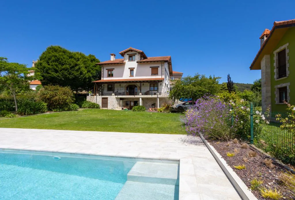 Casa blanca de la posada tras el borde de la piscina