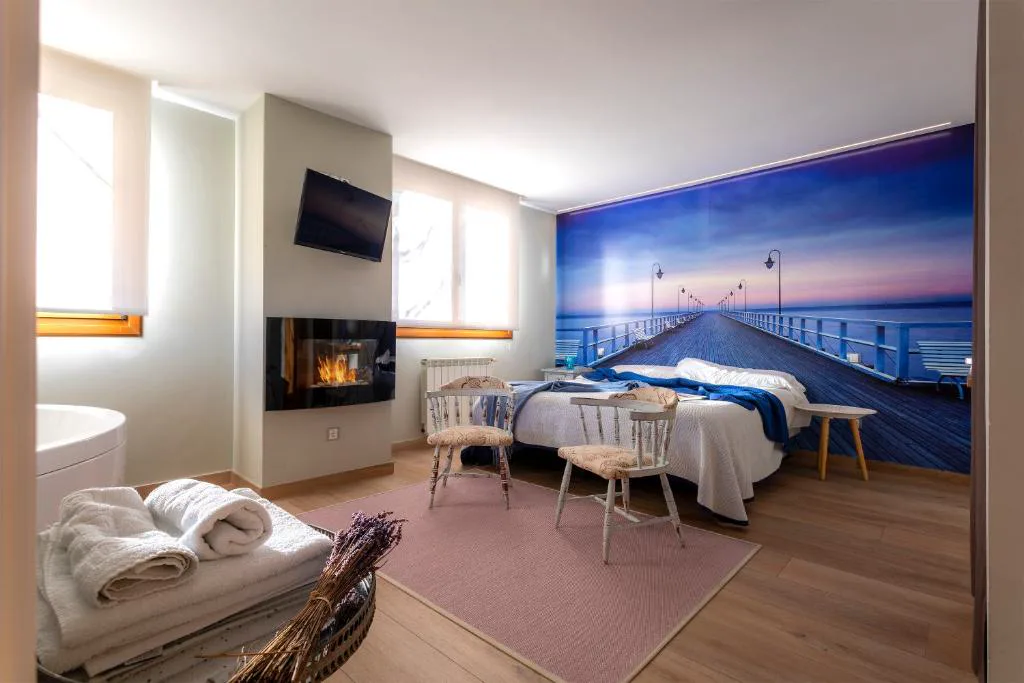 Habitación con chimenea eléctrica y bañera junto a la cama