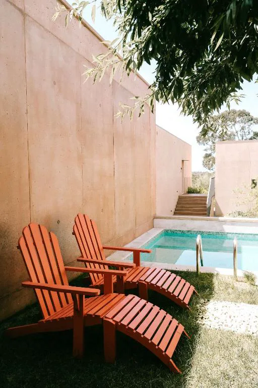 Piscina privada con tumbonas de madera en una villa de Praia do Canal Nature Retreat