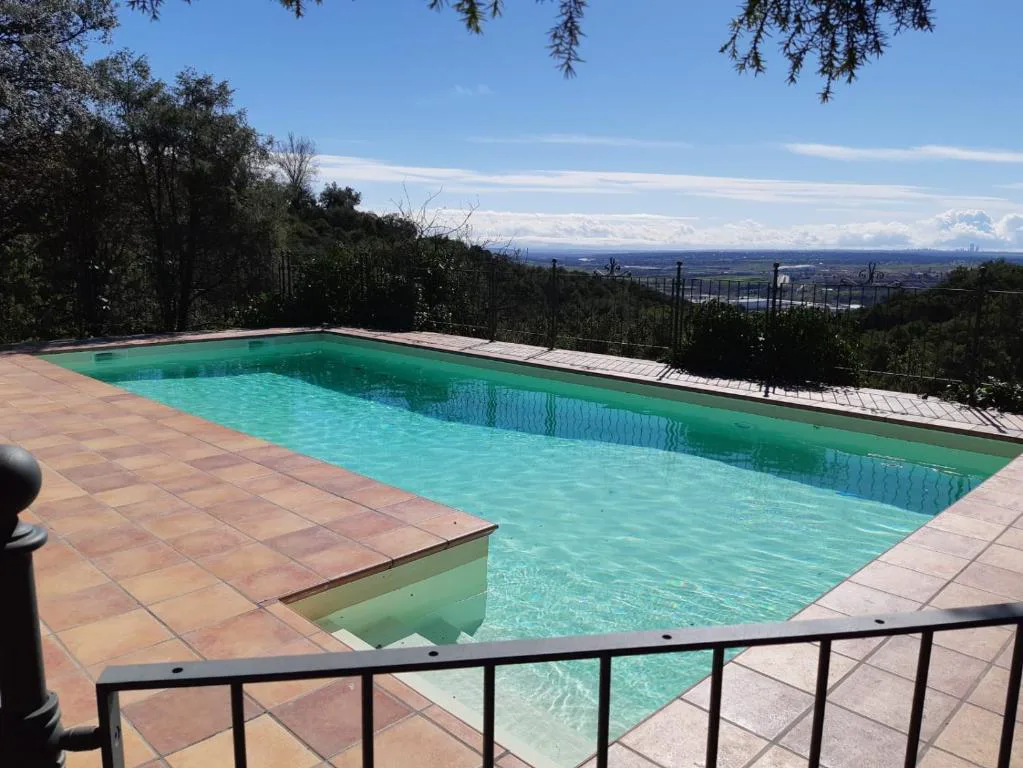 Piscina de agua turquesa con vistas abiertas a la sierra y al valle