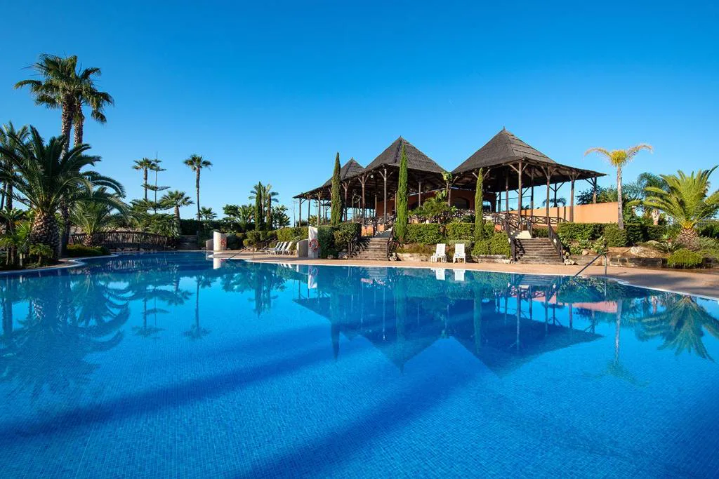 Piscina exterior con cenadores de madera