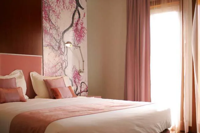Habitación en tonos rosas con mural de flor de cerezo sobre el cabecero, Quinta das Lagrimas