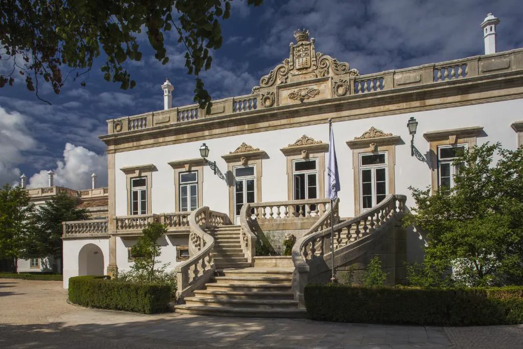 Fachada barroca del palacete de Quinta das Lagrimas con escalinata doble y escudo de armas, en Coímbra