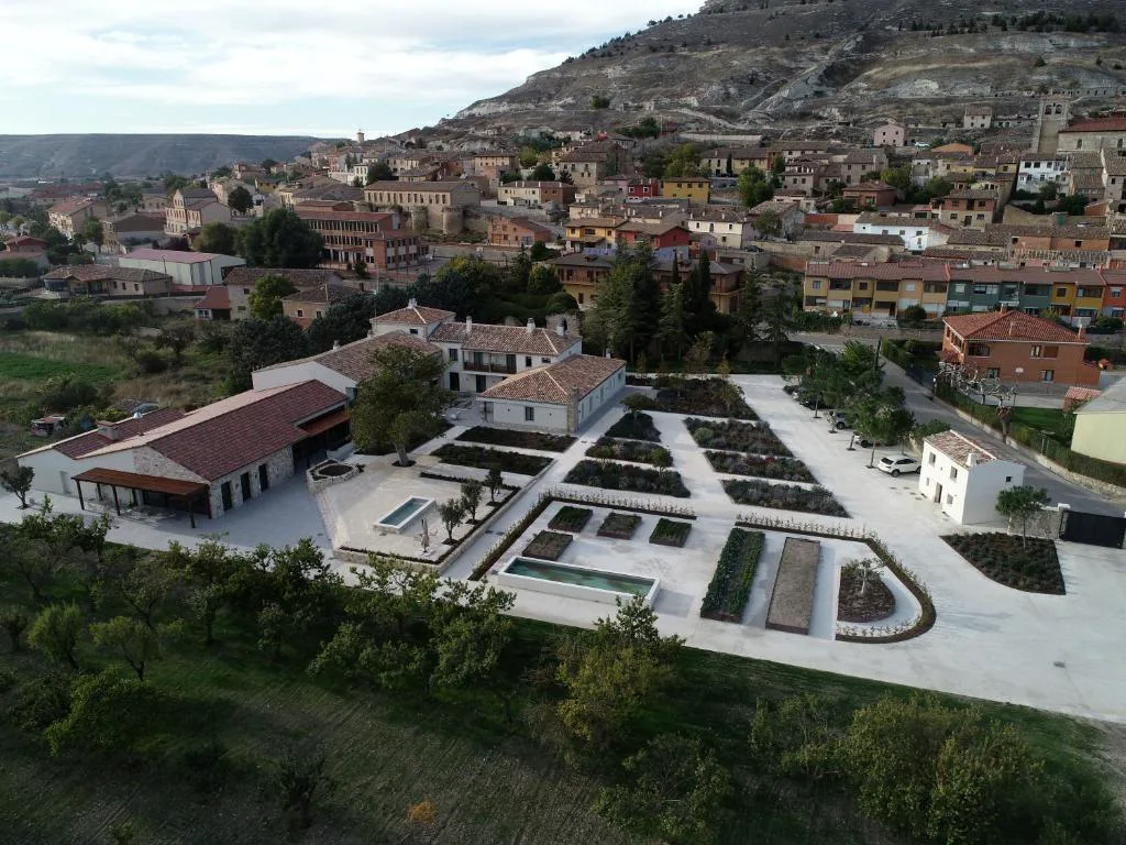Vista aérea del hotel sobre el pueblo con la colina detrás