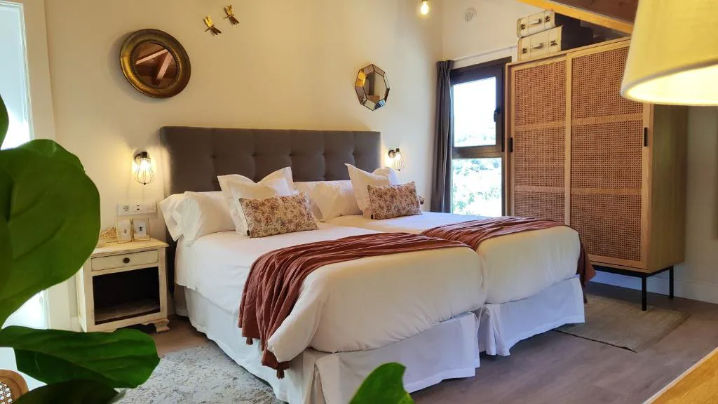 Habitación con cama doble, cabecero de rafia y decoración en tonos cálidos