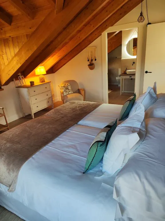 Dormitorio con techo de madera y ropa de cama a rayas
